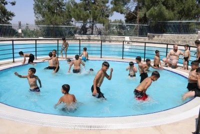 Şanlıurfa'da &ccedil;ocuklar serinliği y&uuml;zme havuzlarında buluyor